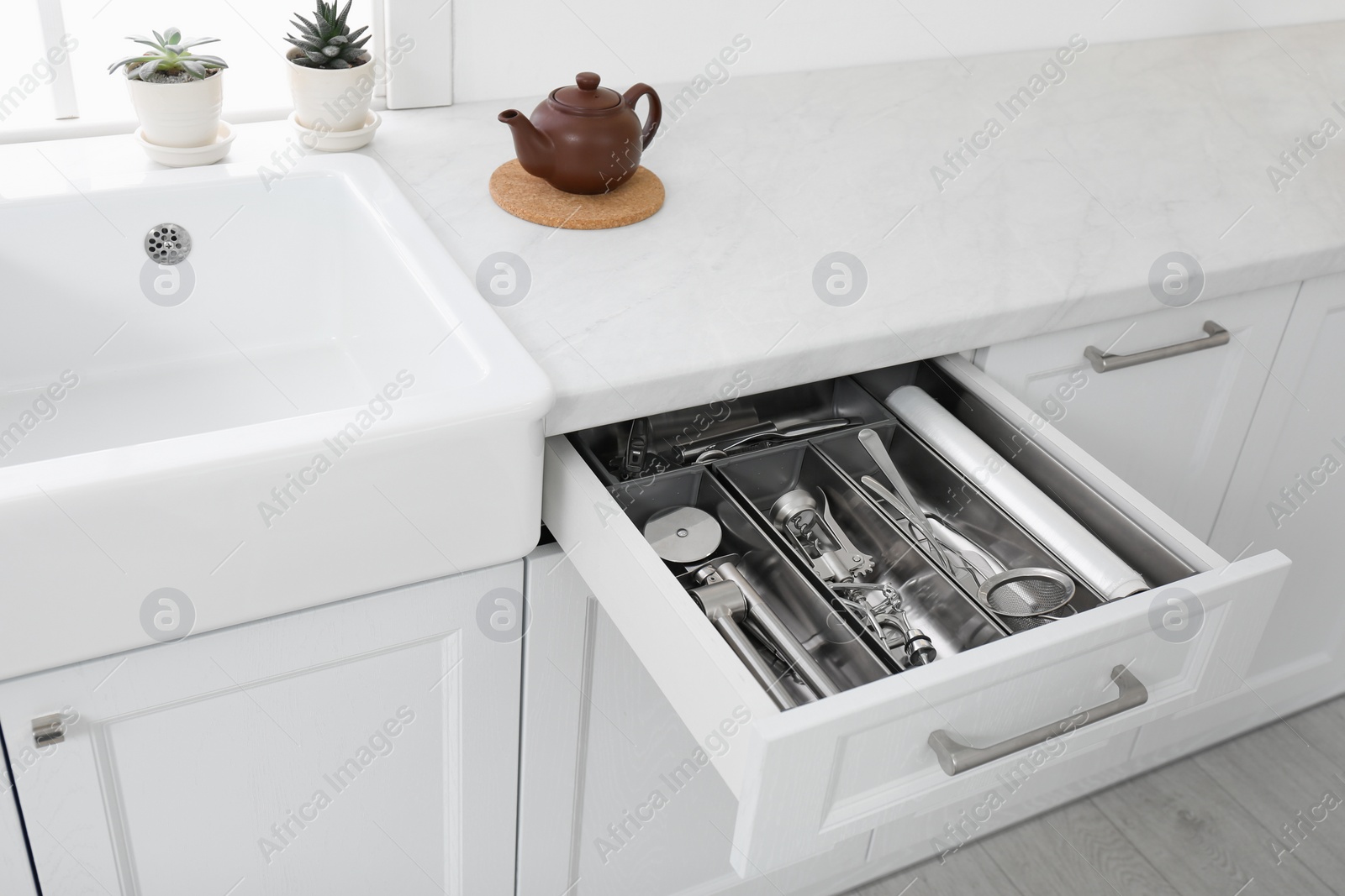 Photo of Open drawer with different utensils in kitchen