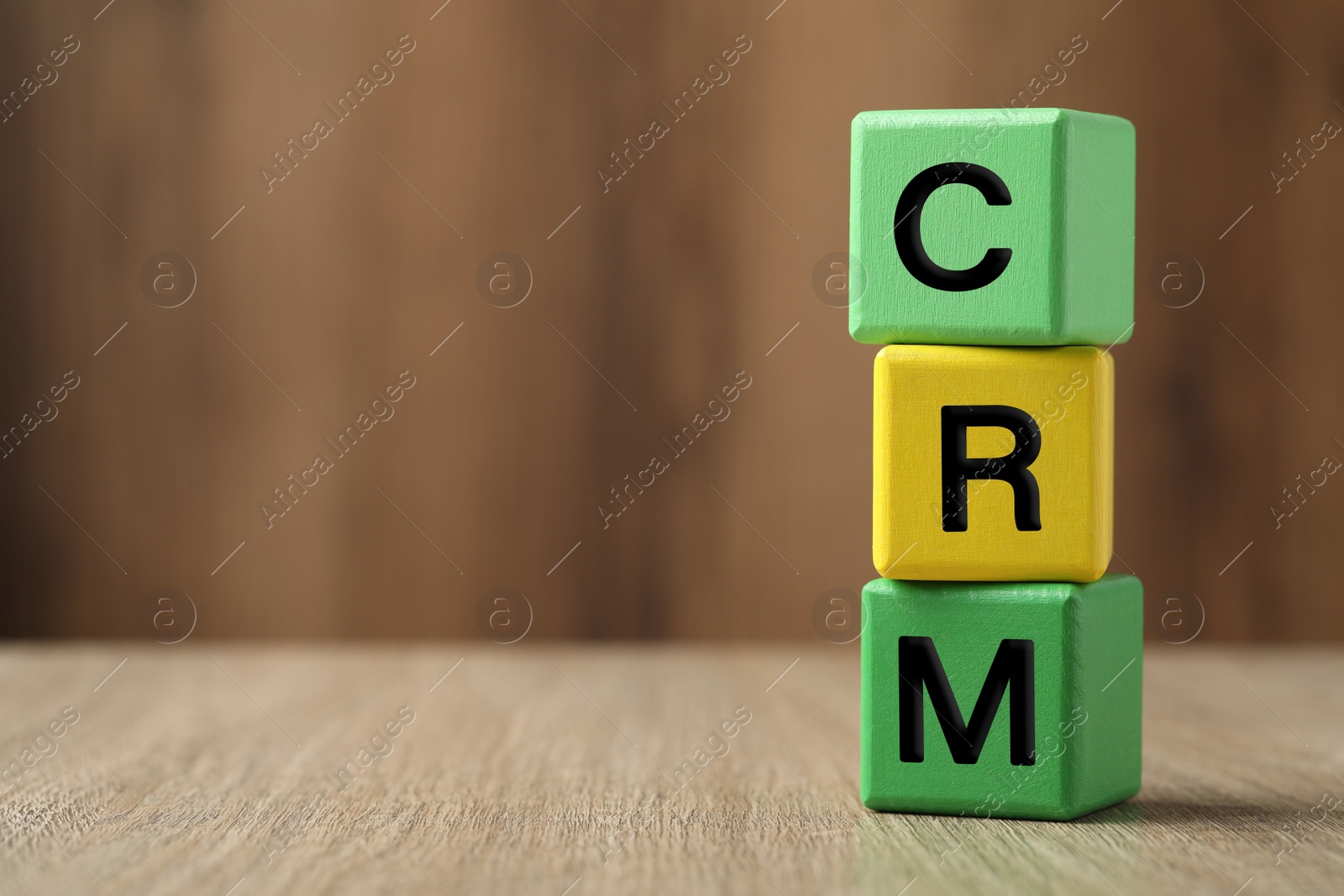 Photo of Abbreviation CRM of cubes on wooden table, space for text. Customer Relationship Management