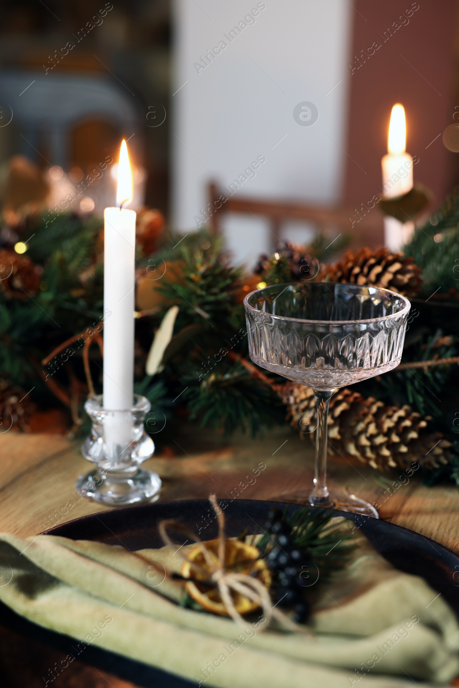 Photo of Burning candles and festive decor on wooden table. Christmas celebration