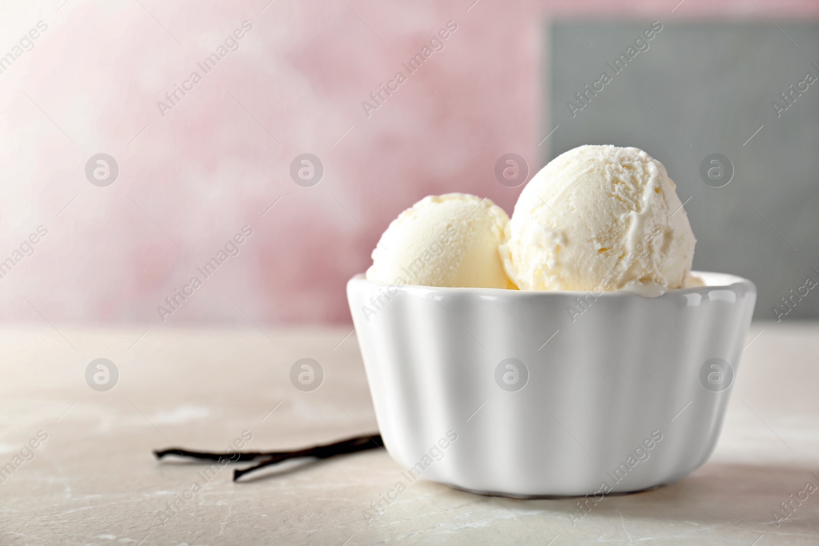 Photo of Bowl with tasty vanilla ice cream on table