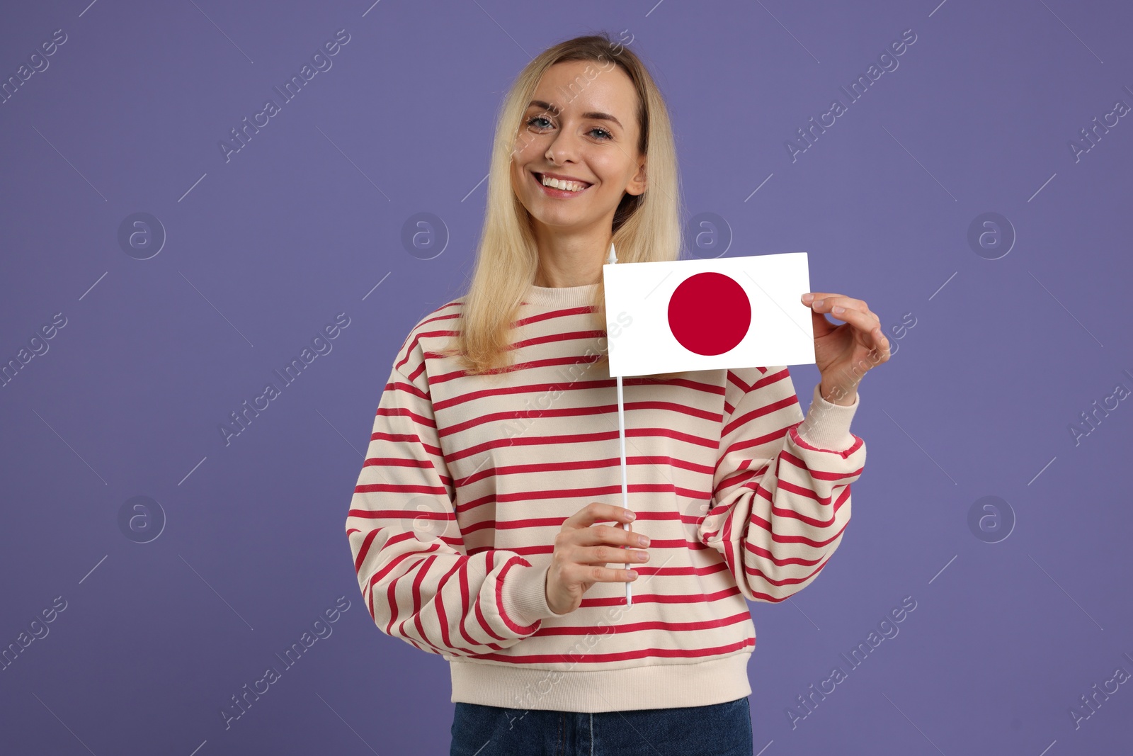 Image of Happy young woman with flag of Japan on purple background