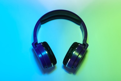 Photo of Stylish headphones on color background, top view