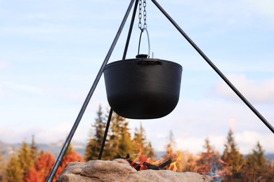 Cooking food on campfire in mountains. Camping season