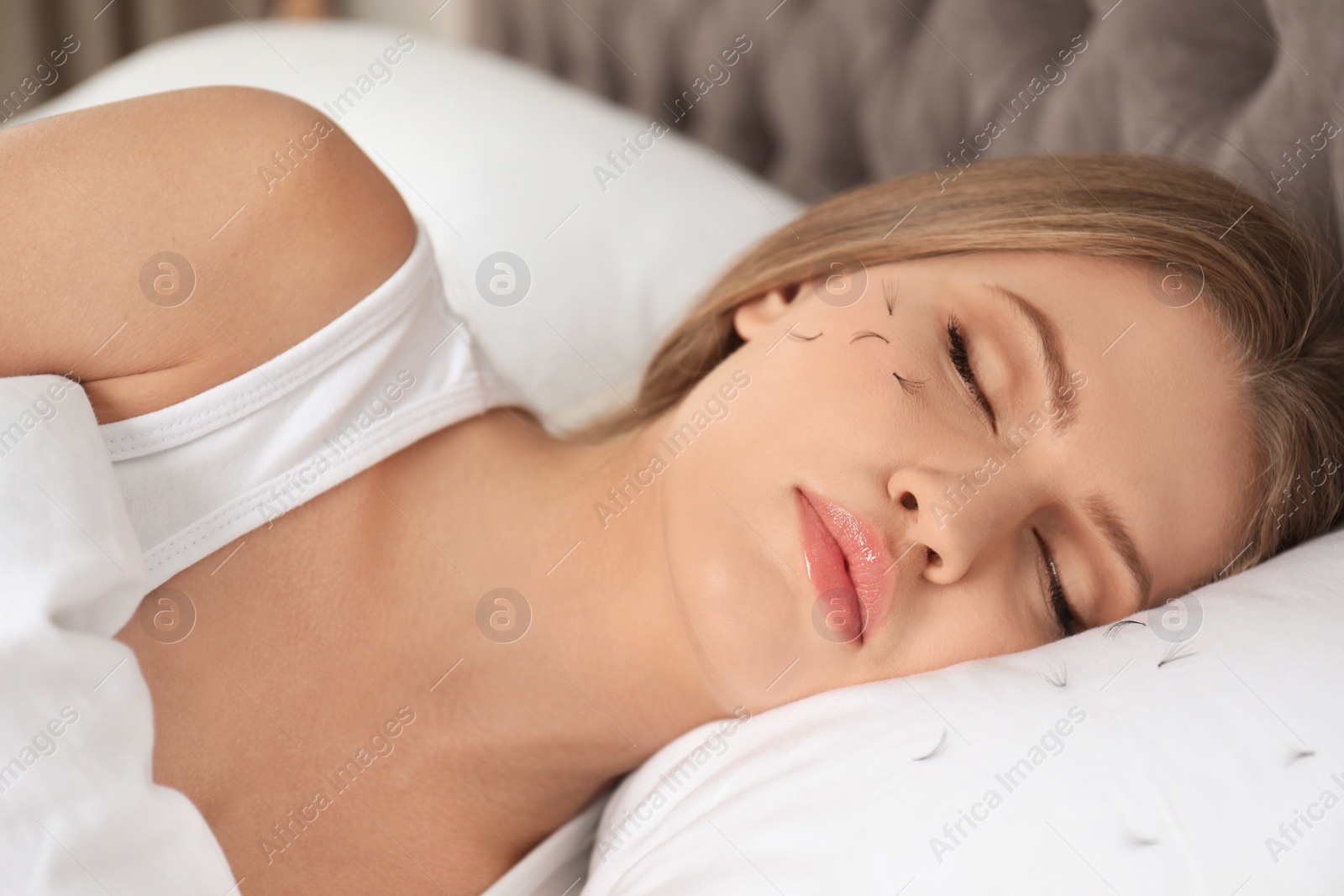 Photo of Young woman with eyelash loss problem sleeping in bed