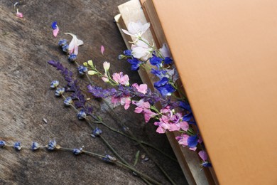 Photo of Beautiful dried flowers and books on wooden table, closeup