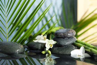 Photo of Spa stones, flowers and bamboo branches in water