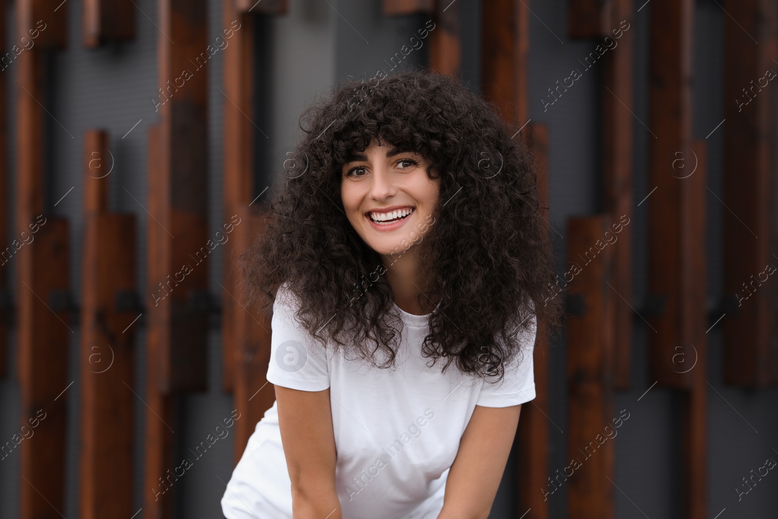 Photo of Portrait of beautiful woman posing near building. Attractive lady smiling and looking into camera