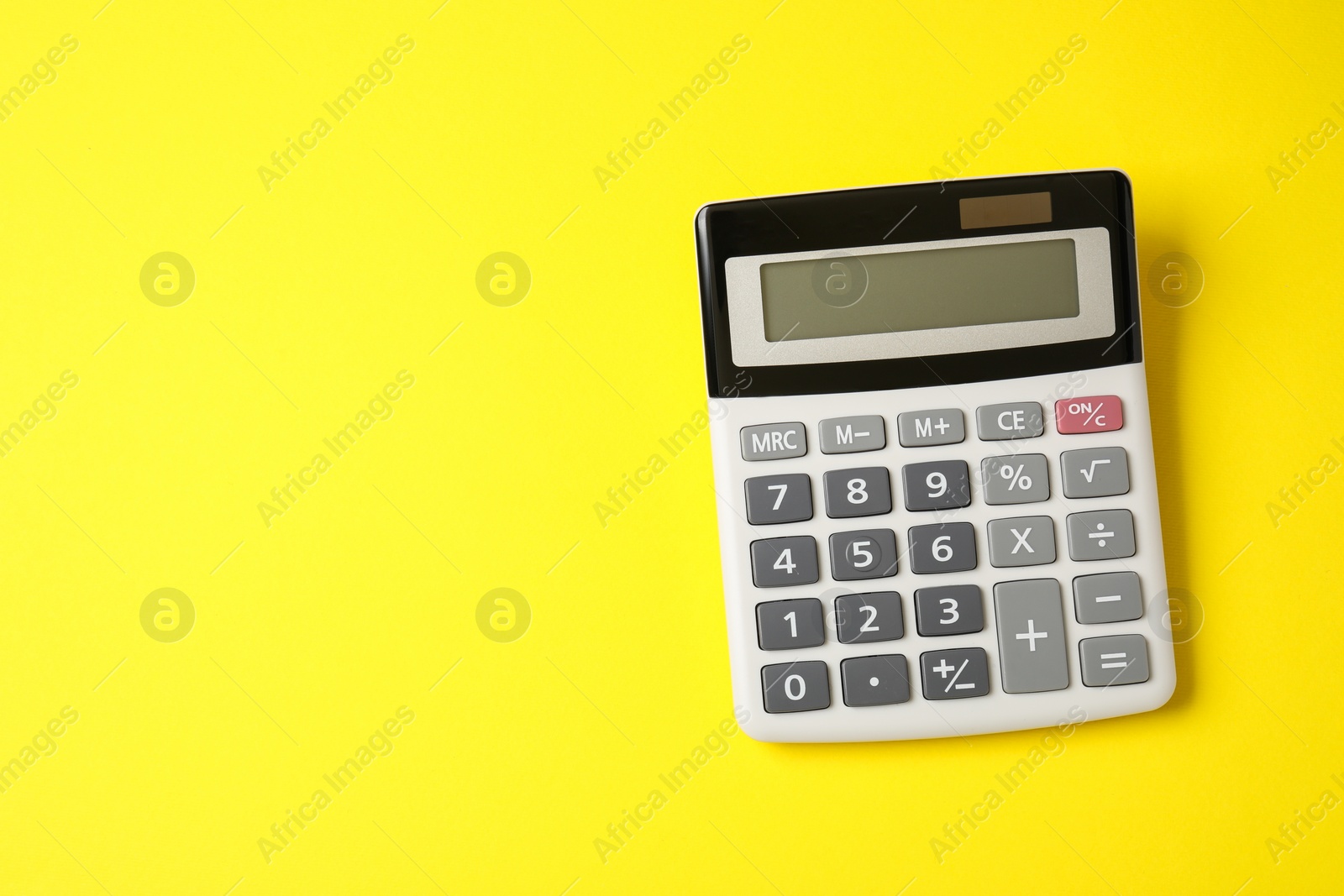 Photo of Calculator on yellow background, top view. Space for text