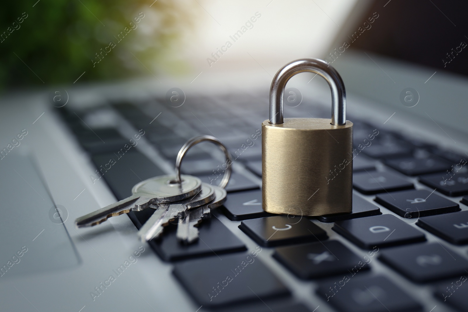 Photo of Metal padlock and keys on laptop keyboard, closeup. Cyber security concept