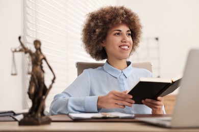 Happy notary with notebook at workplace in office