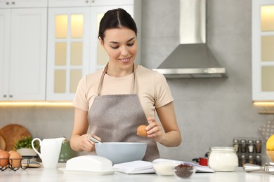 Young woman cooking at countertop in kitchen