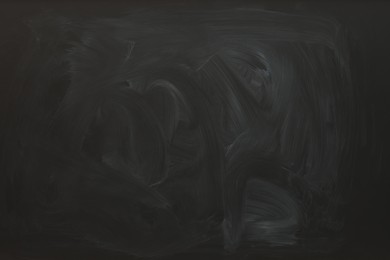 Photo of Dirty black chalkboard as background. School equipment