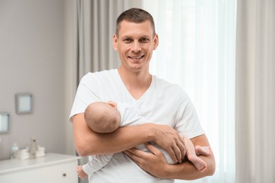 Photo of Happy father holding his cute baby at home