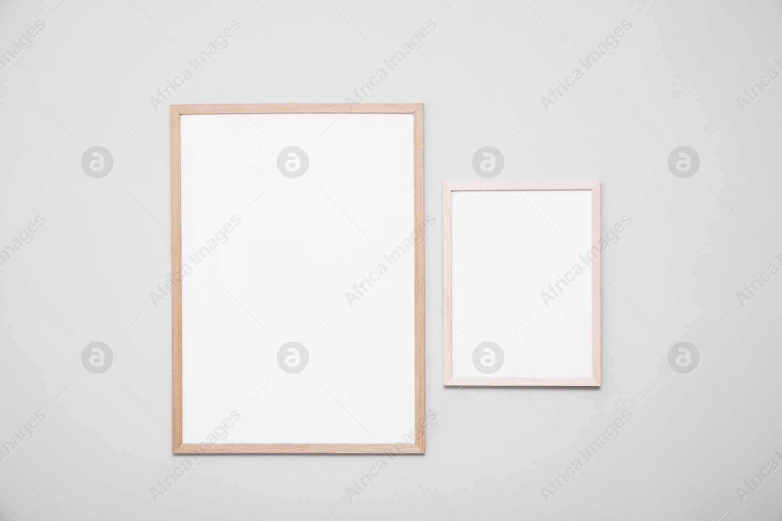 Photo of Empty frames on grey wall. Mockup for design