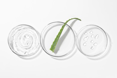 Photo of Petri dishes with aloe plant and cosmetic products on white background, top view