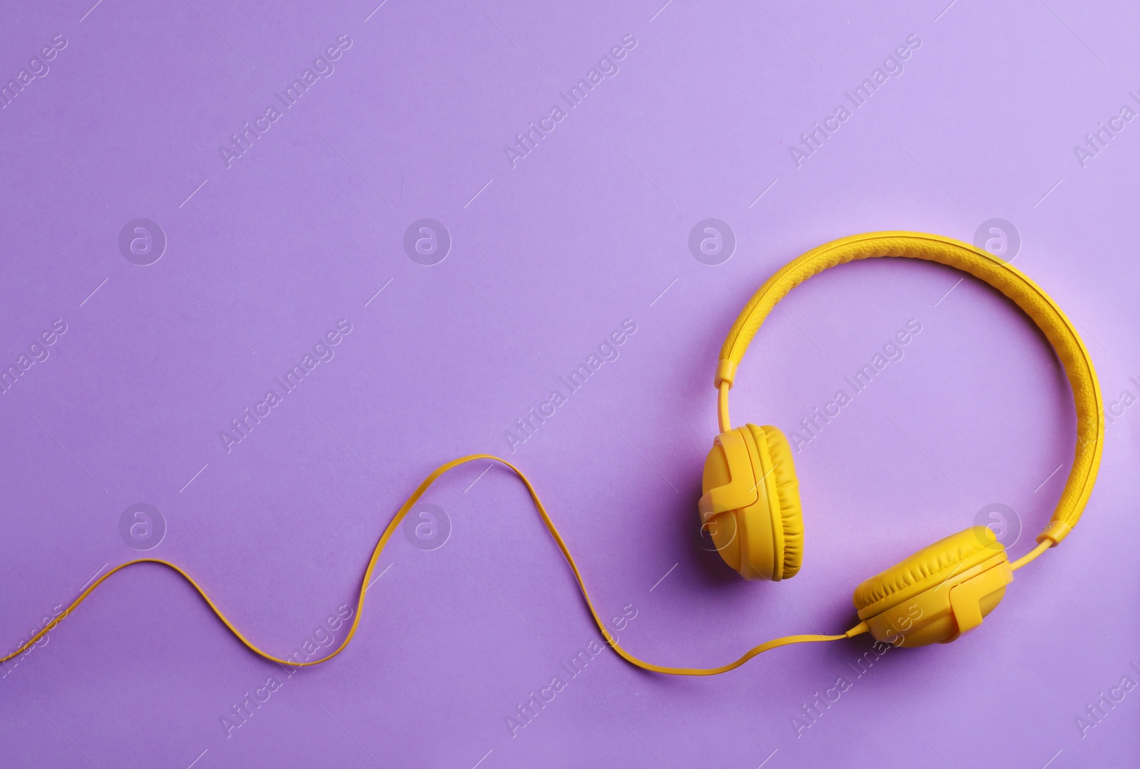 Photo of Stylish headphones on color background, top view. Space for text