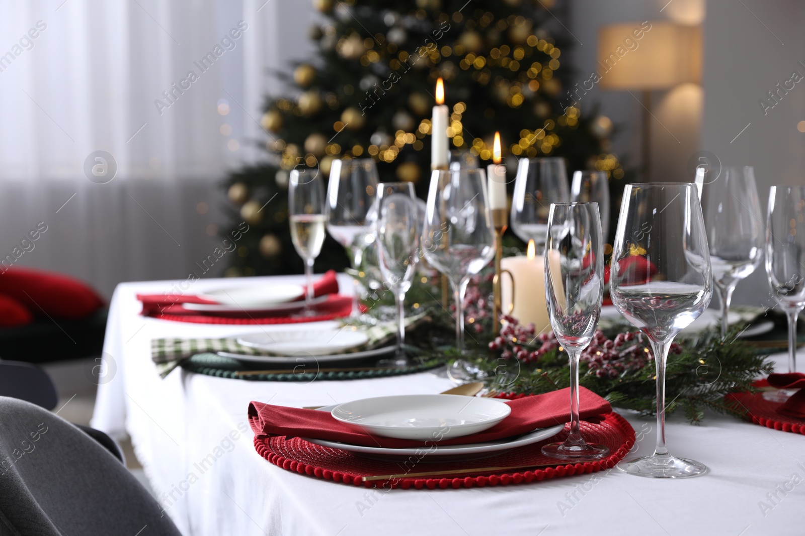 Photo of Christmas table setting with festive decor and dishware in room