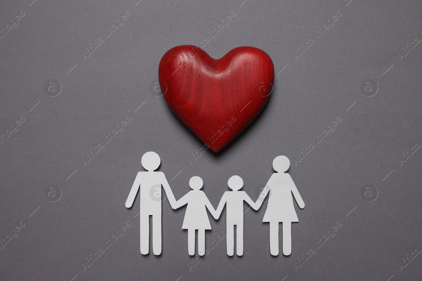 Photo of Paper family figures and red wooden heart on grey background, flat lay. Insurance concept