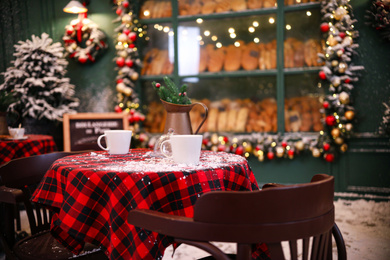 Photo of Served table in modern outdoor cafe. Christmas celebration