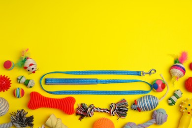 Photo of Flat lay composition with pet leash and toys on yellow background, space for text