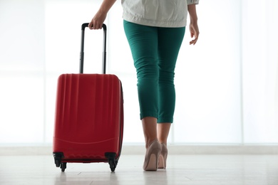 Photo of Businesswoman with red travel suitcase in airport