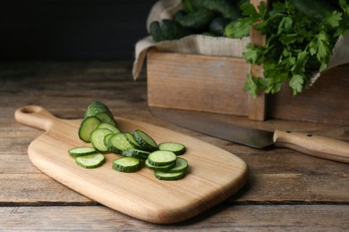 Photo of Slices of fresh ripe cucumber on wooden table