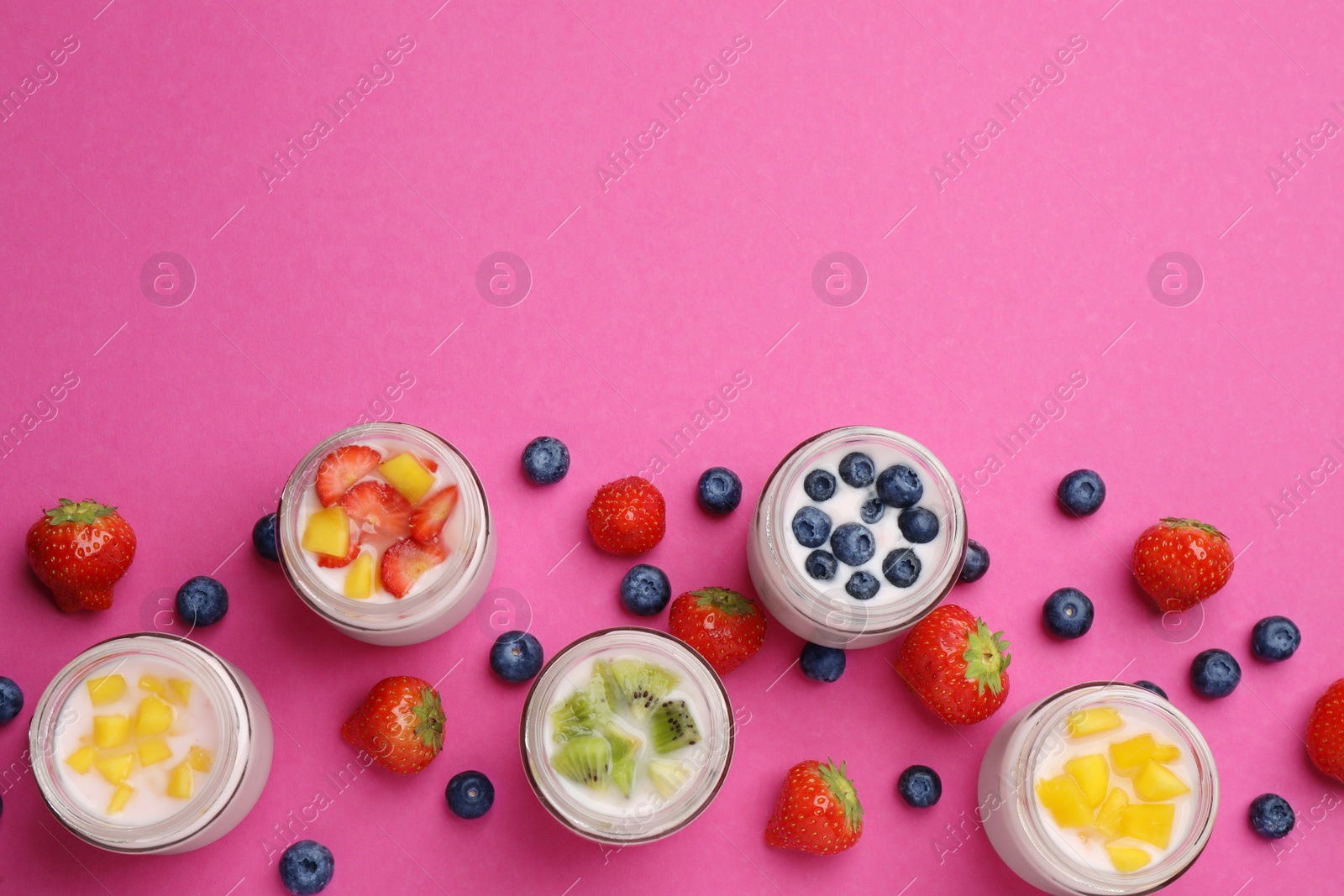 Photo of Jars of fresh yogurt and different fruits on pink background, flat lay. Space for text