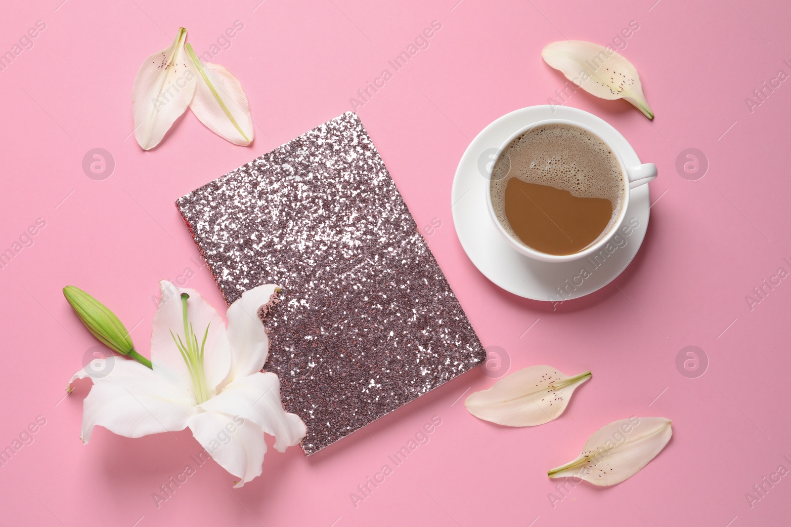 Photo of Beautiful lilies with notebook and coffee on pink background, flat lay