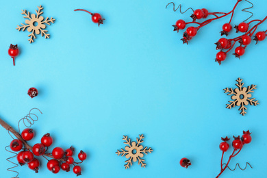 Winter composition with decorative branches on light blue background, flat lay. Space for text