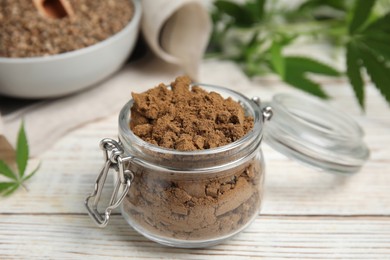 Hemp protein powder on white wooden table, closeup