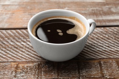 Photo of Cup of aromatic coffee on wooden table, closeup