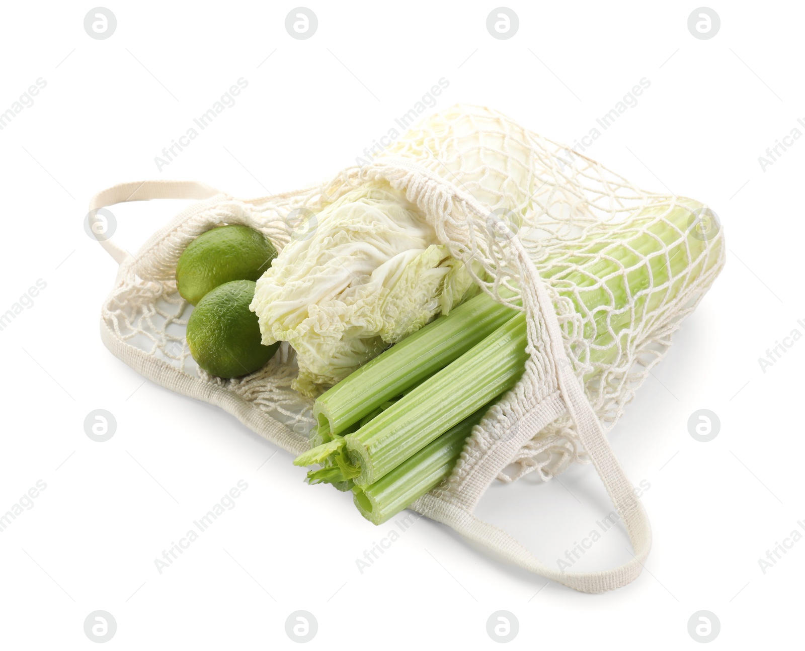 Photo of String bag with different vegetables isolated on white