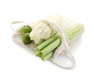 Photo of String bag with different vegetables isolated on white