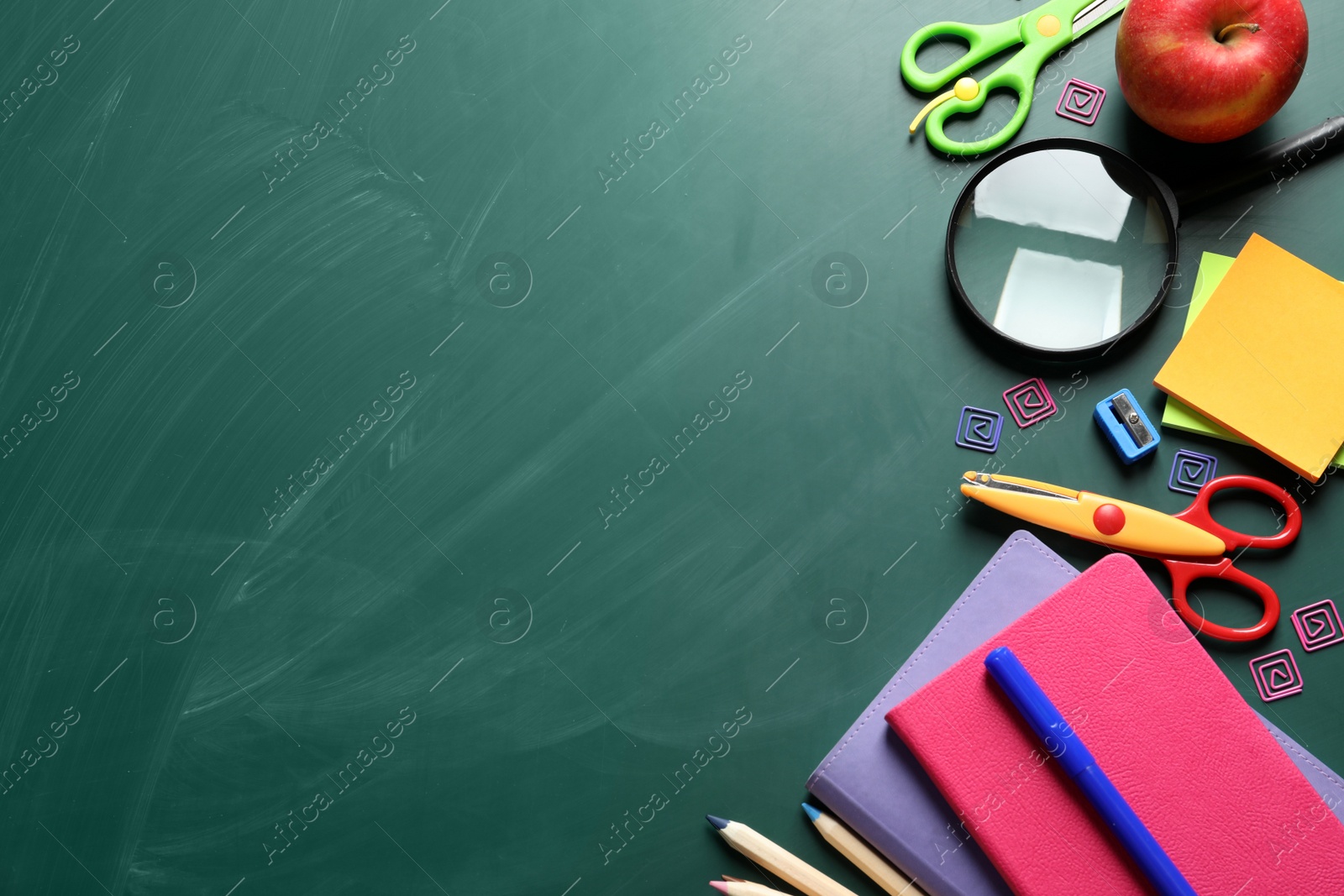 Photo of Flat lay composition with scissors and school supplies on chalkboard. Space for text