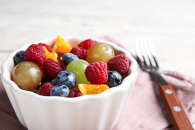 Fresh tasty fruit salad on table, closeup