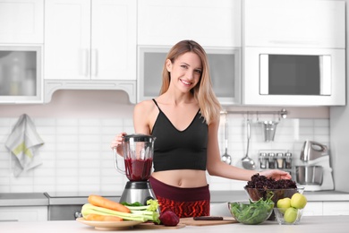 Young woman preparing tasty healthy smoothie at table in kitchen