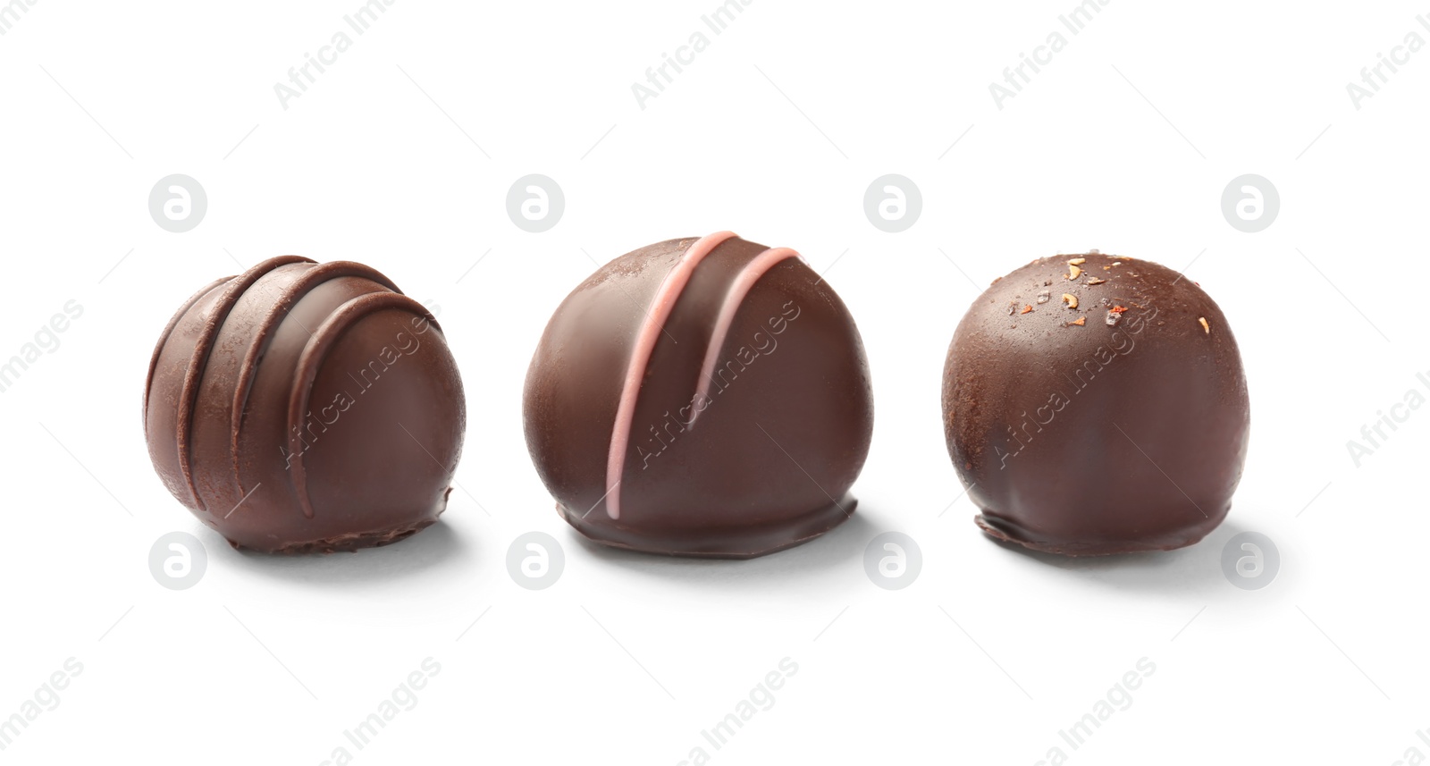 Photo of Three delicious chocolate candies on white background