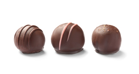 Photo of Three delicious chocolate candies on white background