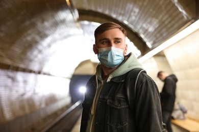 Photo of Young man in protective mask at subway station. Public transport