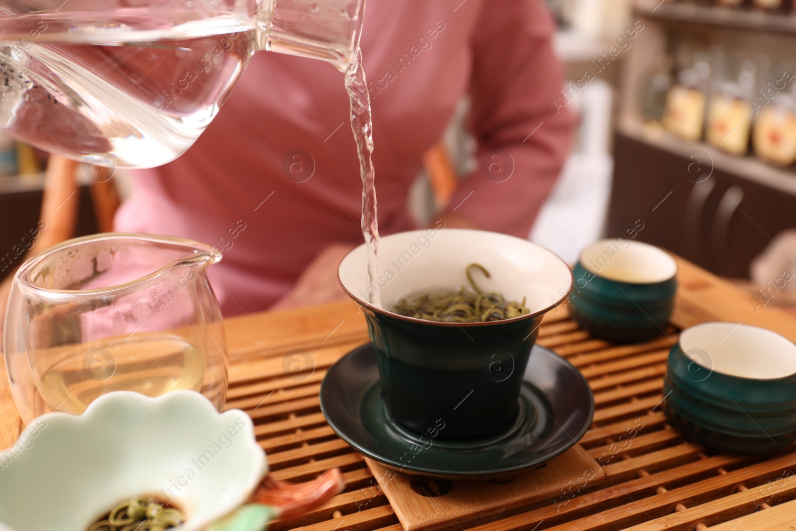 Photo of Master conducting traditional tea ceremony at table, closeup