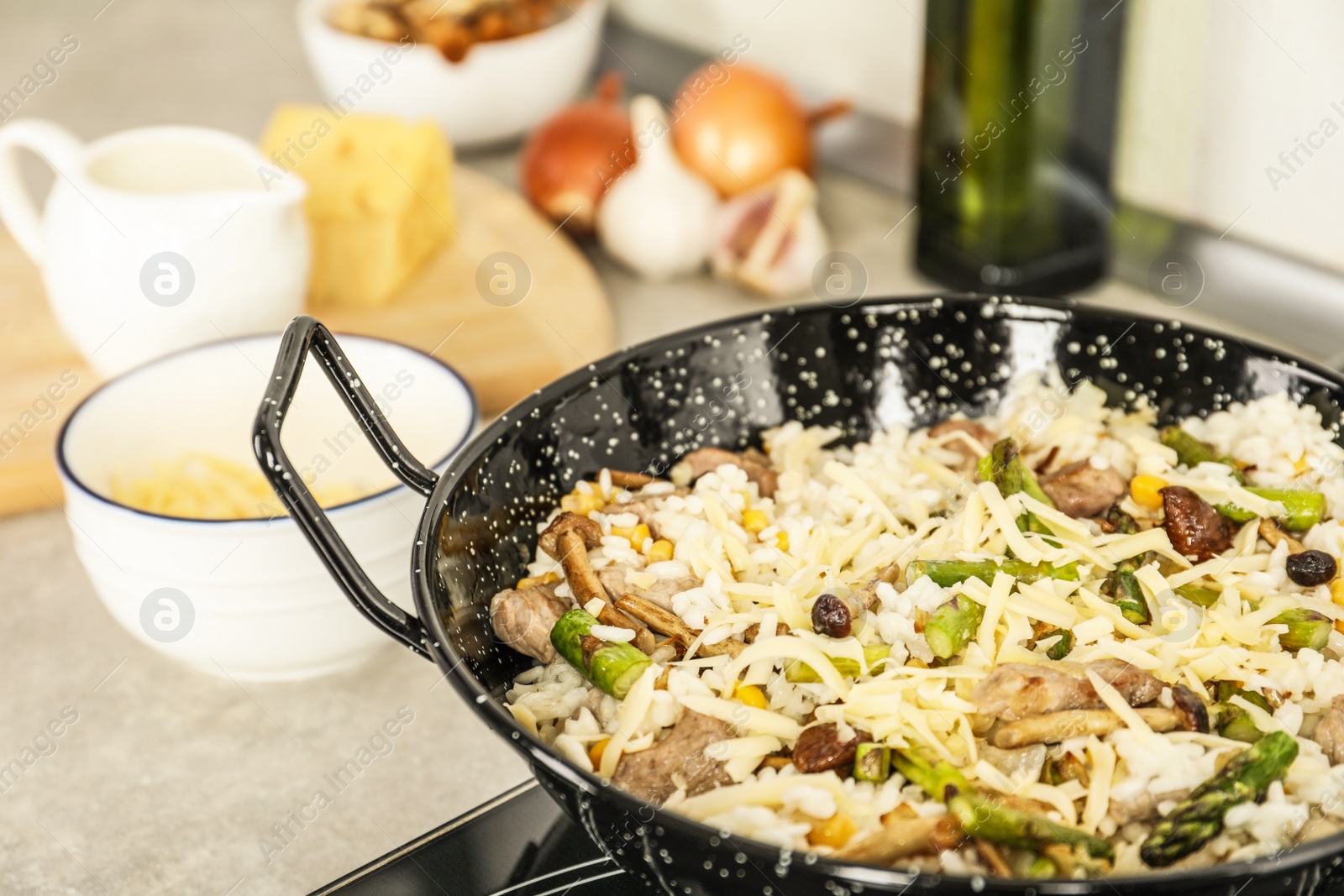 Photo of Delicious risotto in pan on stove, closeup