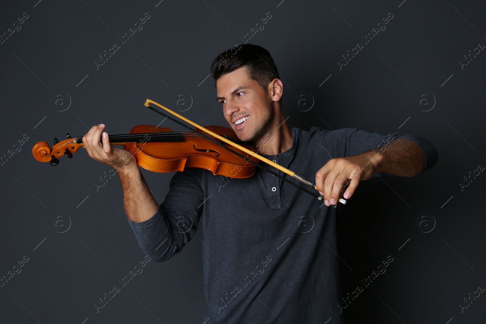 Photo of Happy man playing violin on black background