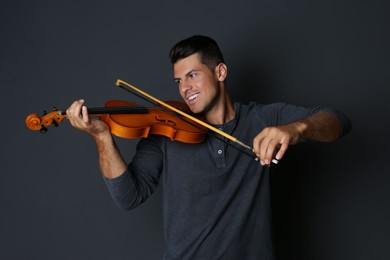 Photo of Happy man playing violin on black background