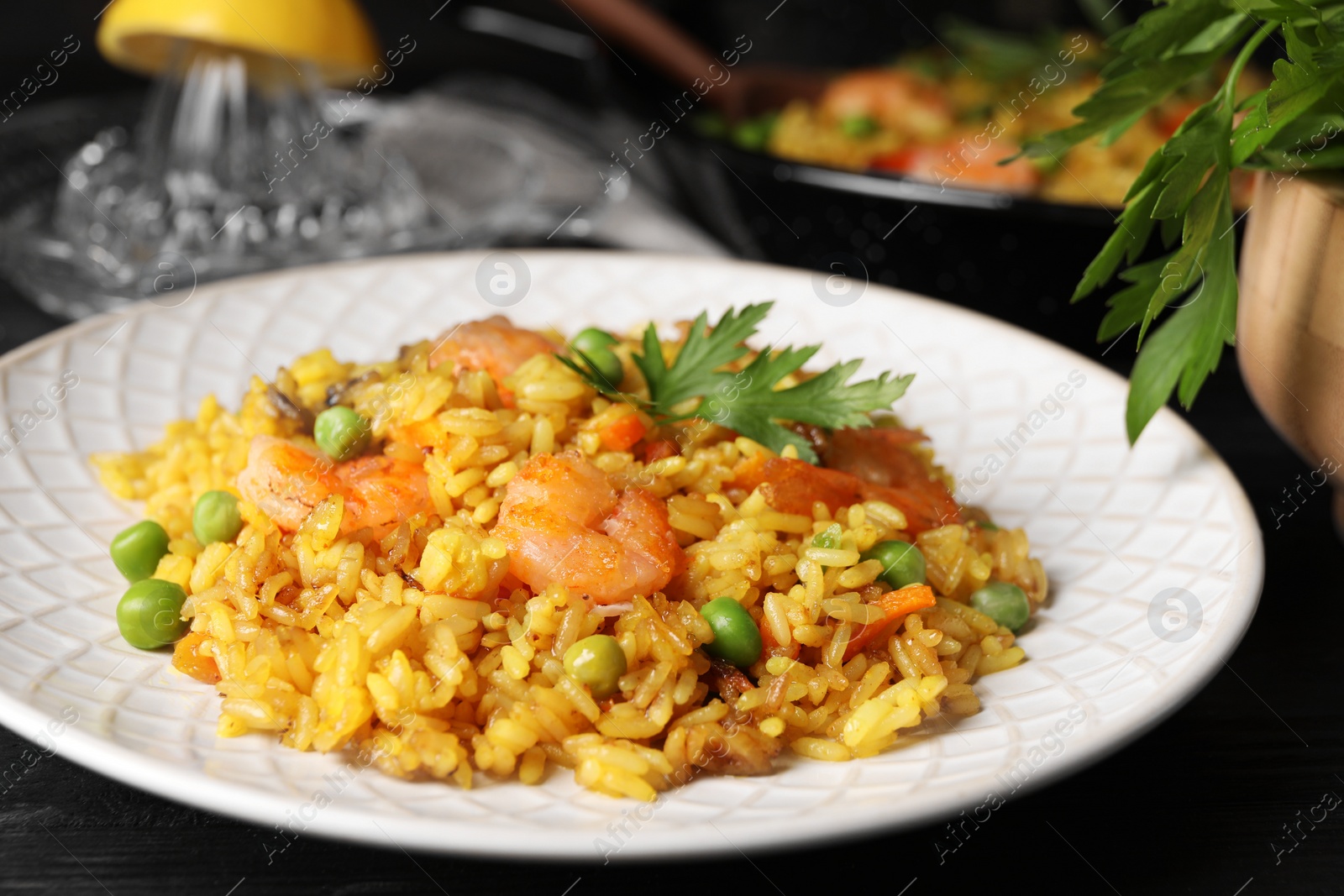 Photo of Tasty rice with shrimps and vegetables on dark table, closeup