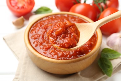 Photo of Eating homemade tomato sauce at white table, closeup