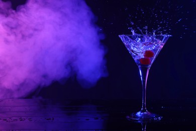 Photo of Martini splashing out of glass in neon lights, space for text
