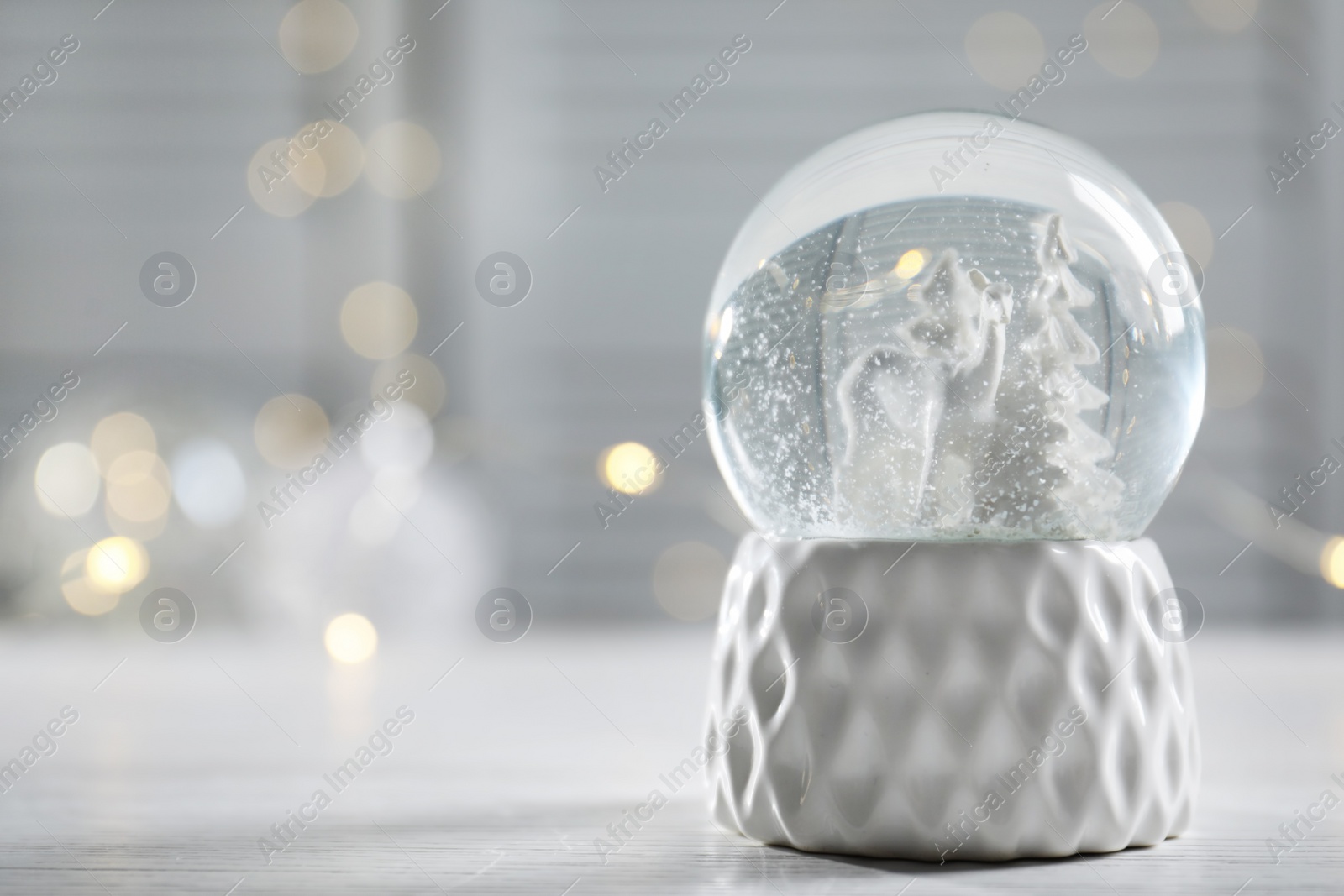 Photo of Christmas snow globe on table. Space for text