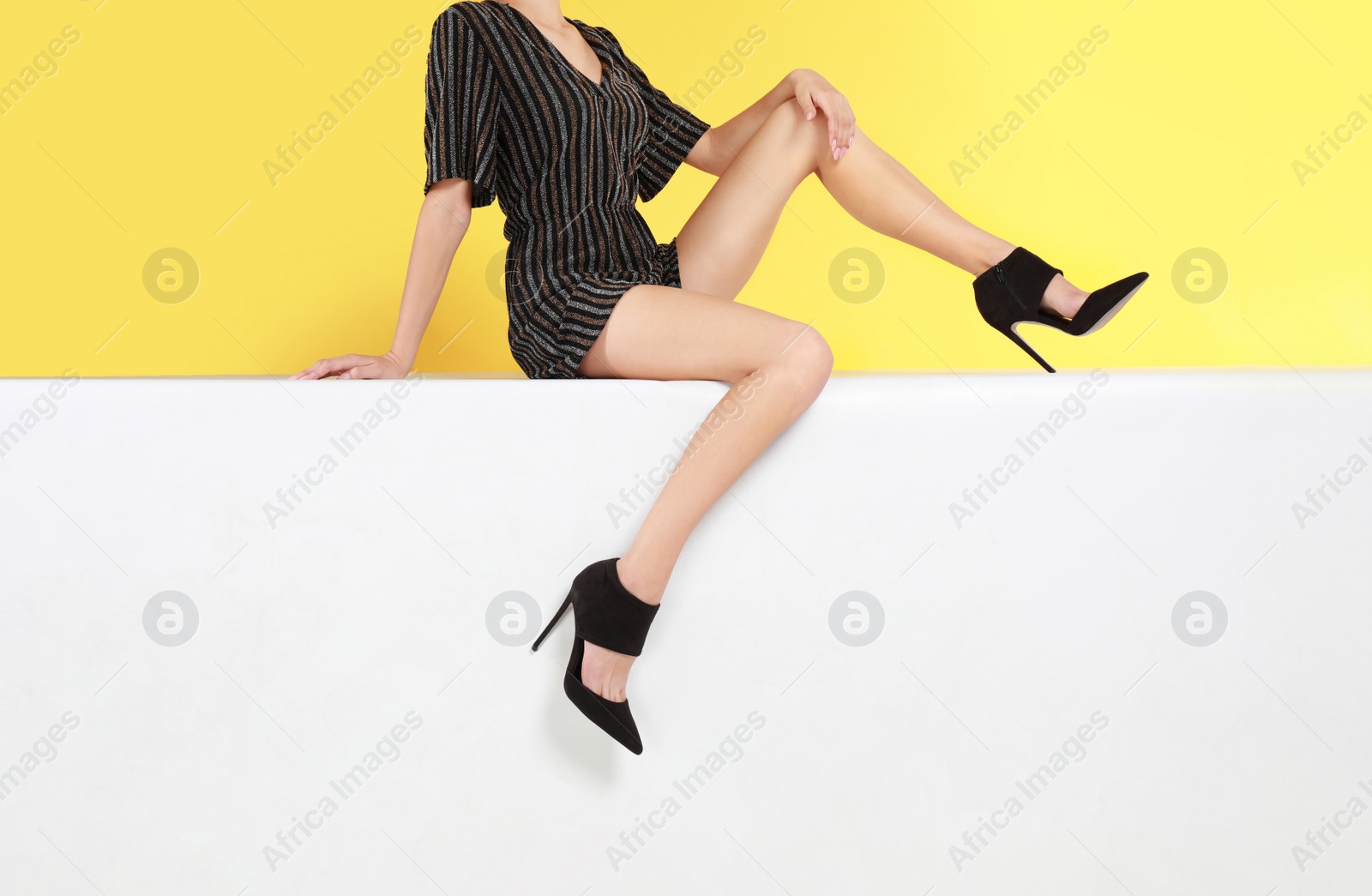 Photo of Woman wearing stylish shoes on color background, closeup