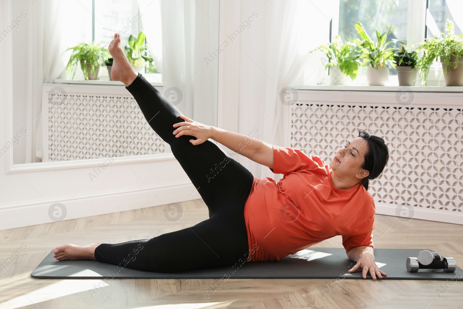 Photo of Overweight mature woman doing exercise at home