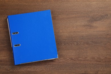 Blue office folder on wooden table, top view. Space for text